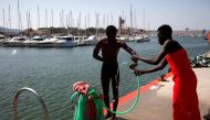 Migrants, part of a group intercepted aboard dinghies off the coast in the Strait of Gibraltar, wash themselves after arriving on a rescue boat at the port of Algeciras, southern Spain, June 26, 2018. REUTERS/Jon Nazca