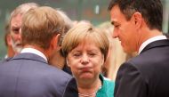 Germany's Chancellor Angela Merkel (C) reacts as she speaks with European Council President Donald Tusk (L) and Spain's Prime Minister Pedro Sanchez during an European Union leaders' summit focused on migration, Brexit and eurozone reforms on June 28, 201