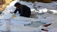 A man holds the body of a dead child among bodies of people activists say were killed by nerve gas in the Ghouta region in the Duma neighbourhood, August 21, 2013. (Reuters / Bassam Khabieh) 
