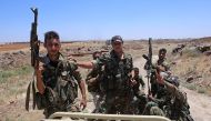 Syrian government forces' soldiers hold their weapons at the back of a pick-up truck during a government guided tour in the village of al-Sourah, province of Daraa, on June 29, 2018. AFP / Youssef Karwashan 