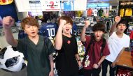 Customers cheer for Japan's national football team at a football sporting goods shop in Tokyo on July 2, 2018. / AFP / Kazuhiro NOGI 