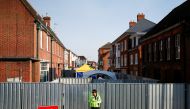 A police officer stands in front of screening erected behind John Baker House, after it was confirmed that two people had been poisoned with the nerve-agent Novichok, in Amesbury, Britain, July 5, 2018. (REUTERS/Henry Nicholls/File Photo)