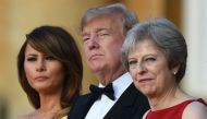 (L-R) US First Lady Melania Trump, US President Donald Trump and Britain's Prime Minister Theresa May stand on steps in the Great Court as the bands of the Scots, Irish and Welsh Guards perform a ceremonial welcome as they arrive for a black-tie dinner wi