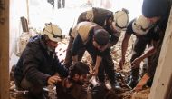 In this file photo taken on April 8, 2017, members of the Syrian civil defence volunteers, also known as the White Helmets, remove a victim from the rubble of his house, following a reported air strike by government forces on a rebel-held area in the sout