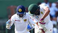 South Africa's Hashim Amla (R) is dismissed by Sri Lankan cricketer Rangana Herath as wicketkeeper Niroshan Dickwella (L) looks on during the third day of their second Test match between Sri Lanka and South Africa at the Sinhalese Sports Club (SSC) intern