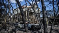 A photo taken on July 25, 2018 shows cars burnt following a wildfire in the village of Mati, near Athens. (AFP / ANGELOS TZORTZINIS)