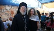 Palestinian activist and campaigner Ahed Tamimi (R) poses for a picture with Archimandrite Abdullah Yulio, parish priest of the Melkite Greek Catholic church in Ramallah, in the West Bank village of Nabi Saleh on July 29, 2018, upon her release from priso
