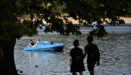 People enjoy the sunshine as thee use a pedalo on the Serpentine lake in Hyde Park in west London on August 6, 2018. AFP / Ben Stansall 