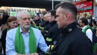 FILE PHOTO: Jeremy Corbyn shakes hands with a fire-fighter lining the street as members of the public take part in a silent march on the first anniversary of the Grenfell fire on June 14, 2018. (AFP / Daniel Leal-Olivas) 