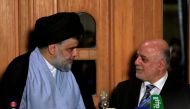 FILE PHOTO: Iraqi Shi'ite cleric Moqtada al-Sadr looks at Iraqi Prime Minister Haider al-Abadi during a news conference in Najaf, Iraq June 23, 2018. Reuters/Alaa al-Marjani 