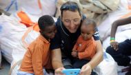 Migrants play with a member of the crew on board the MV Aquarius rescue ship, run by SOS Mediterranee organisation and Doctors Without Borders, during a search and rescue (SAR) operation in the Mediterranean Sea, off the Libyan Coast, August 12, 2018.  12