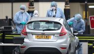 Police forensics officers work around a silver Ford Fiesta car that was driven into a barrier at the Houses of Parliament in central London on August 14, 2018.  AFP / Daniel Leal-Olivas 