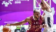 Qatar’s Khalid Abdi (left) dribbles past Hong Kong’s Cheng Kam Hing during their Group C basketball match in  the 2018 Asian Games in Jakarta yesterday.