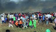 Palestinian medics help a demonstrator who got injured after Israeli forces intervention on the 21st Friday of 