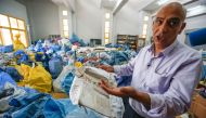 Ramadan Ghazawi, a Palestinian official at the central international exchange post office in the West Bank city of Jericho, holds up a damaged parcel, one of many items of previously undelivered mail dating as far back as 2010 which has been withheld by I
