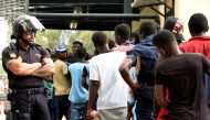African immigrants wait in a row as they enter the immigrant center CETI in the Spanish enclave Ceuta, after some 200 refugees crossed the border fence between Morocco and Ceuta August 22, 2018. REUTERS/Fabian Bimmer