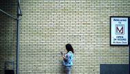A woman stands to the side of a busy sidewalk to look at her mobile phone in New York on August 21, 2018. AFP / Andrew Caballero-Reynolds