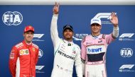 Mercedes' British driver Lewis Hamilton (C) celebrates winning the pole position next to second placed Ferrari's German driver Sebastian Vettel (L) and third placed Force India's French driver Esteban Ocon (R) after the qualifying session at the Spa-Franc