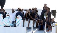 FILE PHOTO: Migrants wait to disembark from the Italian coast guard vessel 