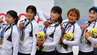 Members of the Unified Korea team pose on the podium after receiving their bronze medals during a medal ceremony for the women's canoe 200m traditional boat race at the 2018 Asian Games in Palembang on August 25, 2018. (AFP / ADEK BERRY)