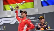 Winner Ferrari's German driver Sebastian Vettel (L) holds his trophy as he celebrates next to third placed Red Bull Racing's Dutch driver Max Verstappen on the podium after the Belgian Formula One Grand Prix at the Spa-Francorchamps circuit in Spa on Augu