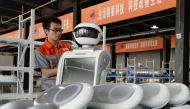 An employee assembles a robot at a factory in Handan in China's northern Hebei province on August 27, 2018. The company provides personalized robots used for customer services. AFP 

 