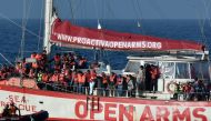 (FILES) In this file photo taken on May 7, 2018 rescued migrants stand onboard the Open Arms Yacht of Spanish based non-governmental organisation Proactiva, some 35 nautical miles off Libya coast.  AFP / LOUISA GOULIAMAKI