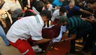 Paramedics help a female health officer who was injured as Israeli forces intervene to disperse Palestinian protestors on the 23rd Friday near Gaza-Israel border in Rafah, Gaza on August 31, 2018. ( Abed Rahim Khatib - Anadolu Agency )