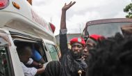 Ugandan singer-turned-politician Robert Kyagulanyi (C), better known as Bobi Wine, reacts as he gets into an ambulance after being released on bail at The High Court in Gulu, northern Uganda, on August 27, 2018.  / AFP / Stringer 