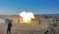 Syrian government artillery guns firing during bombardment against Islamic State (IS) group positions along the frontline in the Safa hills, in the southern Sweida province.  SANA