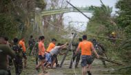 Rescue workers clear a road of debris and toppled electric posts caused by strong winds due to super Typhoon Mangkhut as they try to reach Baggao town in Cagayan province, north of Manila September 15, 2018. AFP / TED ALJIBE