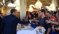 French President Emmanuel Macron (L) shakes people's hands as visitors are allowed access to the Elysee Palace in Paris on September 15, 2018, as part of France's Heritage Days. / AFP / POOL / Anne-Christine POUJOULAT