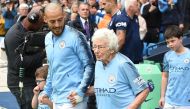Manchester City's Spanish midfielder David Silva (L) holds the hand of 102-year-old mascot Vera Cohen at the start of the English Premier League football match between Manchester City and Fulham at the Etihad Stadium in Manchester, north west England, on 