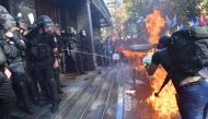 Activists of Ukrainian far-right groups burn a fire during their clashing with riot police in front of the Prosecutor General's Office in Kiev on September 17, 2018 as the Ukrainian authorities extradited a Russian citizen wanted by Moscow as a suspected 