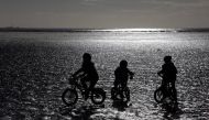 Children ride their bike along the beach during low tide near St Helier, Jersey November 11, 2012. Reuters/Stefan Wermuth