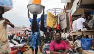 Akua Agyeawa poses for a portrait in front of her clothing stand in Madina, Ghana, July 3, 2018. Thomson Reuters Foundation/Nellie Peyton
