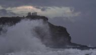 Waves hit the cliffs in front of the ancient Temple of Poseidon at cape Sounion, in southern Athens during bad weather on September 29, 2018. / AFP / Aris MESSINIS