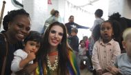 Drag performer Topsy Redfern poses for a photo with members of staff and children at London Early Years Foundation nursery in London, United Kingdom on August 24, 2018. Thomson Reuters Foundation / Cormac O'Brien