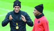 aris Saint-Germain's German coach Thomas Tuchel (L) speaks with Paris Saint-Germain's French forward Kylian Mbappe (R) during a training session on the eve of the team's Champions League football match against Belgrad (Crvena zvezda) on October 2, 2018 at