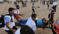 A wounded Palestinian is evacuated during a protest calling for lifting the Israeli blockade on Gaza and demanding the right to return to their homeland, at the Israel-Gaza border fence in the southern Gaza Strip October 12, 2018. Reuters/Ibraheem Abu Mus