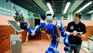 An employee makes humanoid robot Justin move his arms in a laboratory at the German Aerospace Center (DLR) in Wessling, near Munich, Germany, October 4, 2018. Reuters/Andreas Gebert
