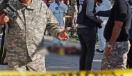 Police standing near the body of a suicide bomber who blew herself up near police vehicles in the centre of the Tunisian capital Tunis. / AFP / STRINGER
