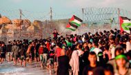 Palestinians protesters carry national flags as they gather during a demonstration calling for an end to the Israeli blockade on Gaza, on a beach in Beit Lahia near the maritime border with Israel, on November 5, 2018. AFP / Mahmud Hams

