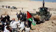 REPRESENTATIVE IMAGE: Palestinians gather in front of an Israeli bulldozer at Palestinian Bedouin village of Khan al-Ahmar in the occupied West Bank, September 14, 2018. Reuters/Mussa Qawasma
