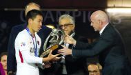FIFA president Gianni Infantino (right) presents the trophy to Kashima Antler’s defender Gen Shoji after the AFC Champions League final match against Iran’s Persepolis at the Azadi Stadium in Tehran, yesterday.