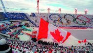 In this file photo taken on February 13, 1988 fans cheer and wave flags as the Canadian delegation (lower right) parades during the opening ceremony of the XVth Winter Olympic Games in Calgary. AFP / Jonathan Utz