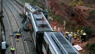 Emergency personnel stand at the site where a commuter train derailed in the town of Vacarisses, about 35 kilometres (20 miles) northeast of Barcelona, on November 20, 2018. AFP / Pau Barrena
