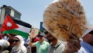 FILE PHOTO: Protesters chant slogans as they hold bread in front of the Labour Union offices in Amman, Jordan, June 6, 2018. REUTERS/Muhammad Hamed