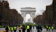 Demonstrators walk near the Arc de Triomphe during a protest of Yellow vests (Gilets jaunes) against rising oil prices and living costs, on December 1, 2018 in Paris.  AFP 
