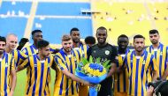 Al Gharafa players presenting a flower bouquet to the newly crowned AFC Player of the Year, Al Sadd’s Abdelkarim Hassan prior to the kickoff of yesterday’s match.